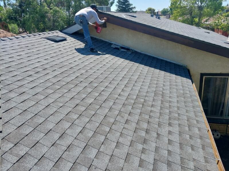 Trabajador realizando labores sobre un techo residencial