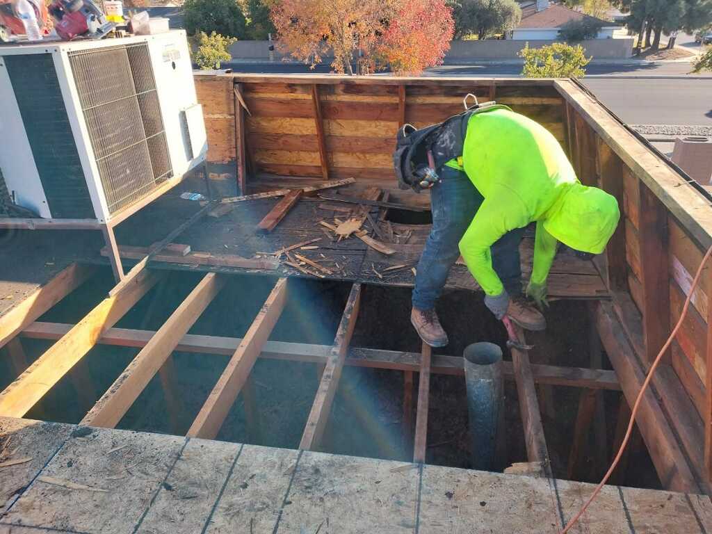 Trabajador realizando labores sobre la estructura del techo